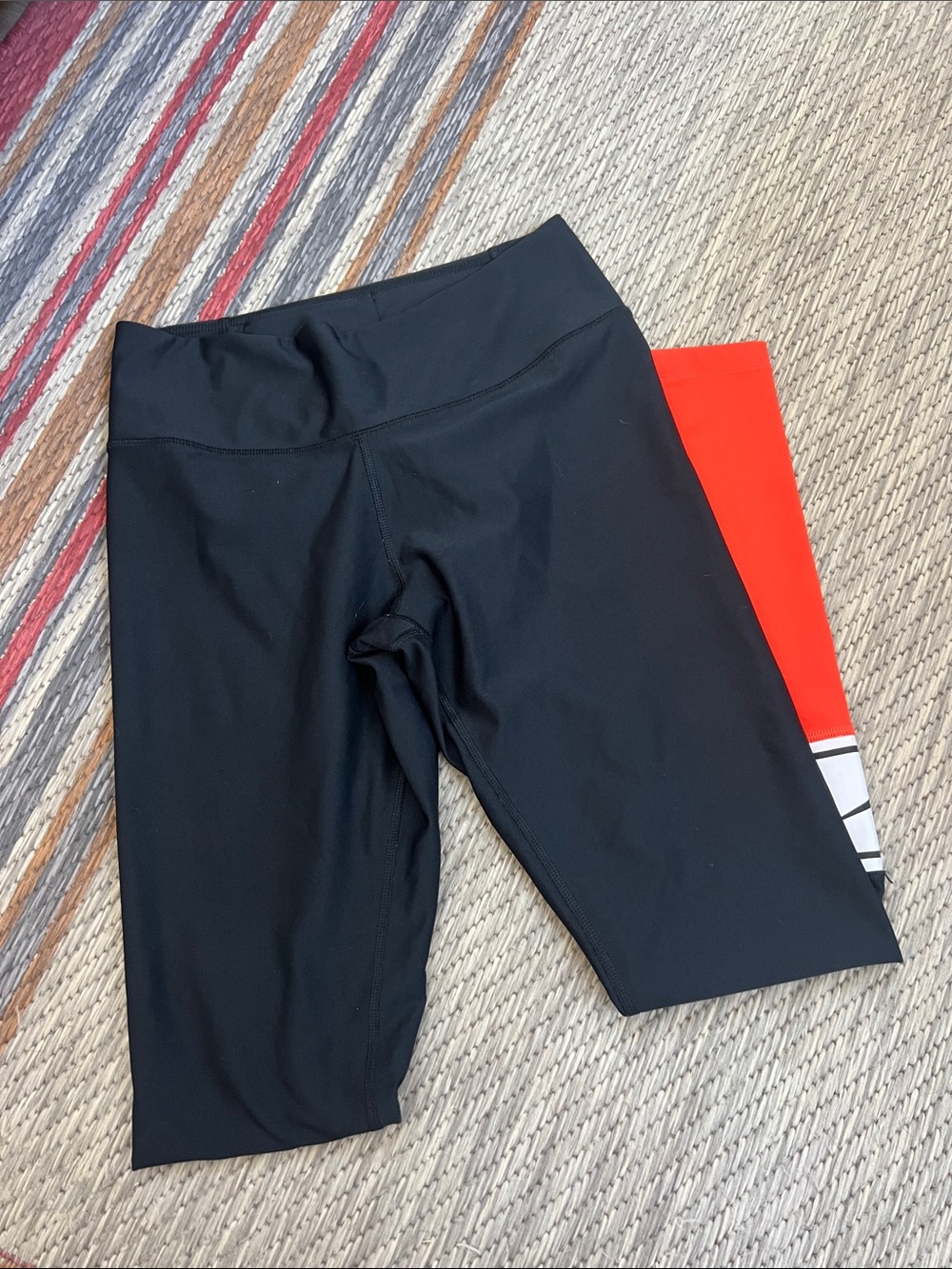 Women’s Black Nike leggings with orange sleeve on leg, size Small